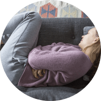 Woman in fetal position on sofa